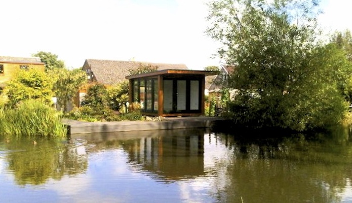 Garden room overlooking a canal with swans passing by