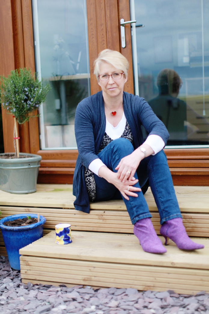 Nicola Morgan sitting on her garden studio steps